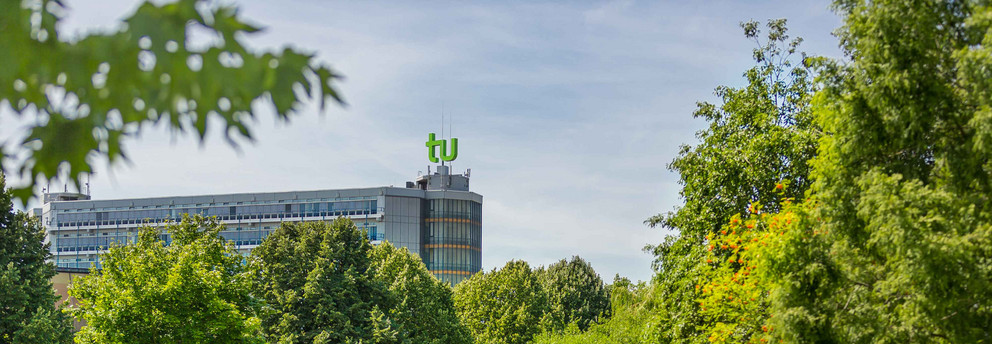 Das Mathematikgebäude mit grünen Bäumen im Vordergrund.